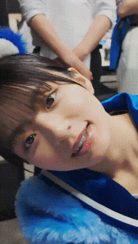 a close up of a woman 's face with a blue jacket on