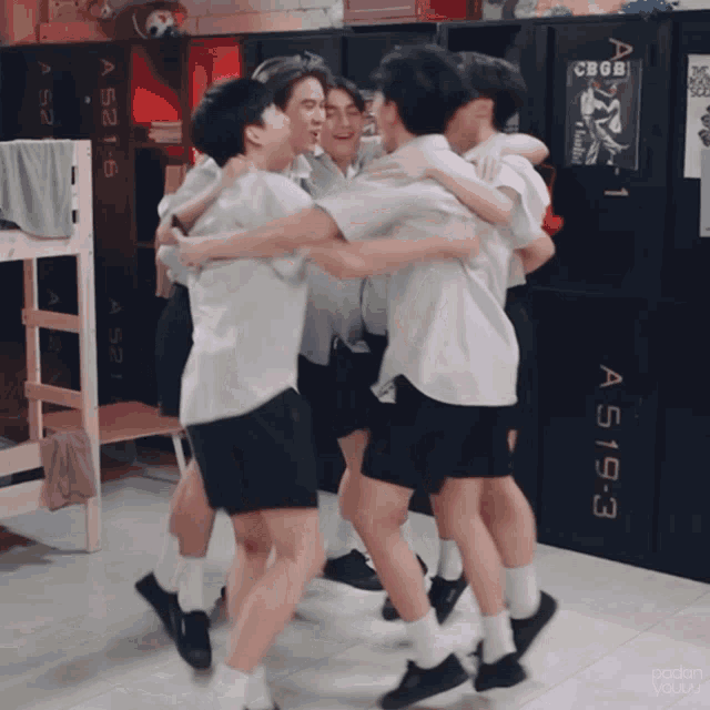 a group of young men hugging each other in front of a sign that says a519-3