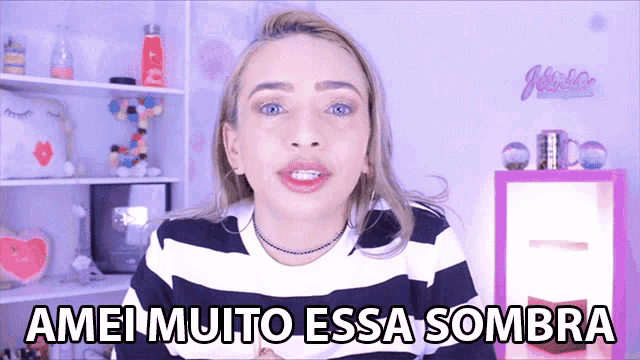 a woman wearing a black and white striped shirt says ameimuito essa sombra