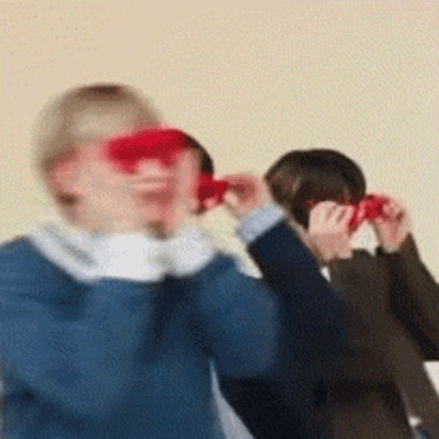 a blurry picture of two people holding red hearts in front of their faces