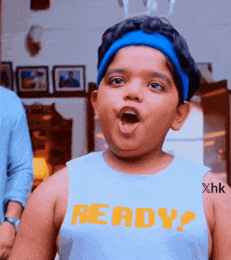a young boy is wearing a blue tank top that says ready