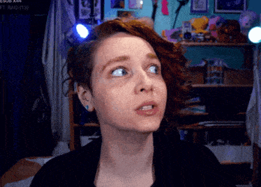 a woman with red hair looks up at something in front of a sign that says sub x44