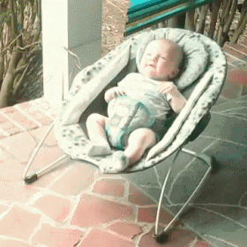 a baby is sitting in a bouncer on a patio