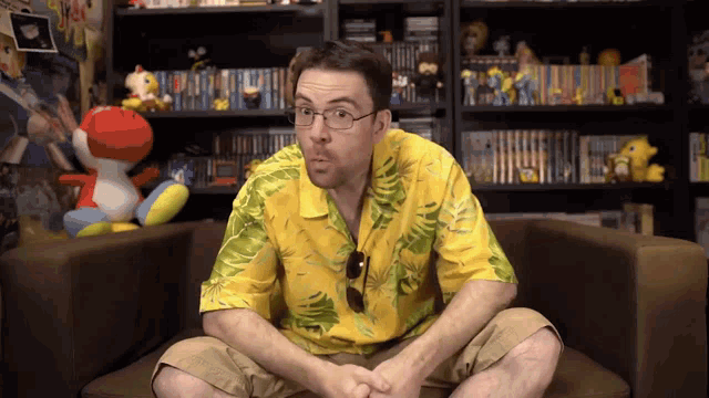 a man in a yellow shirt sits in a chair