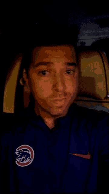 a man wearing a blue nike shirt with a chicago cubs logo on it