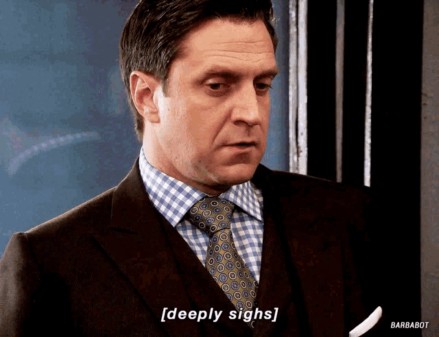 a man in a suit and tie says " deeply sighs " on the screen