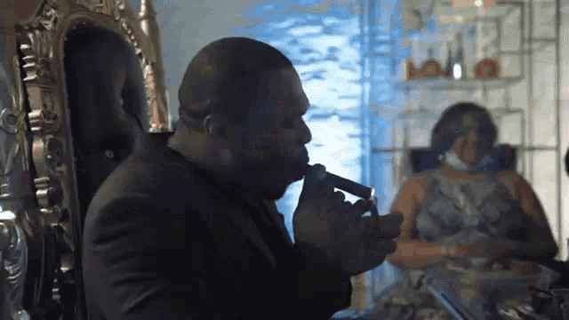 a man in a suit is smoking a cigar