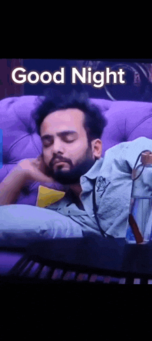 a man with a beard is sleeping on a couch .