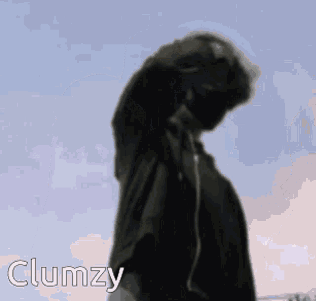 a person wearing headphones is standing in front of a blue sky and the word clumzy is on the bottom