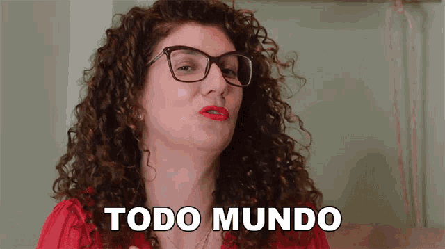 a woman with curly hair is wearing glasses and says todo mundo