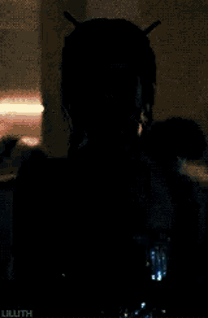 a woman in a strapless dress is standing in a dark room with a blurred background .
