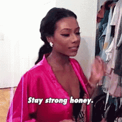 a woman in a pink robe is saying `` stay strong honey '' .