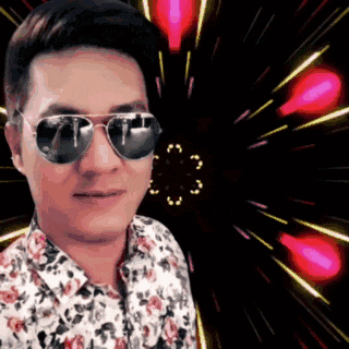 a man wearing sunglasses and a floral shirt is standing in front of a fireworks display