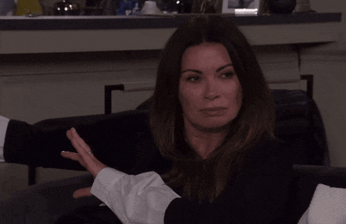 a woman is sitting on a couch with her eyes closed and a ring on her finger