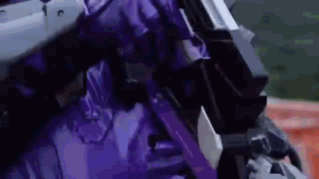a close up of a person in a purple suit holding a sword .