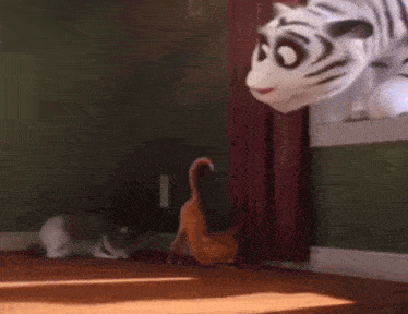 a stuffed animal of a tiger is standing in a room next to a cat and a rabbit .