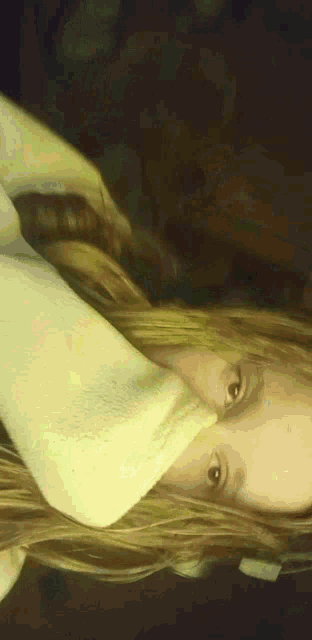 a close up of a girl 's face with a yellow blanket covering it