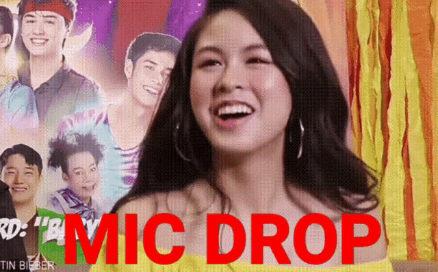 a woman is smiling in front of a poster that says ' mic drop '