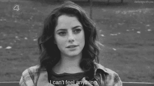 a black and white photo of a woman sitting on a bench with the words i can 't feel anything .
