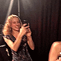 a woman in a dress is taking a picture of herself in a mirror
