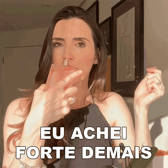 a woman holding a bottle of perfume with the words eu achei forte demais below her