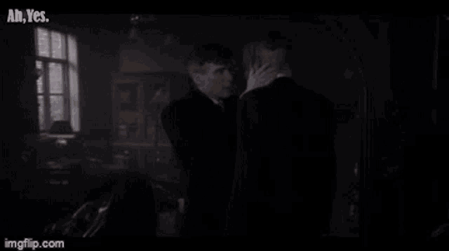 a man is holding another man in his arms in a room .