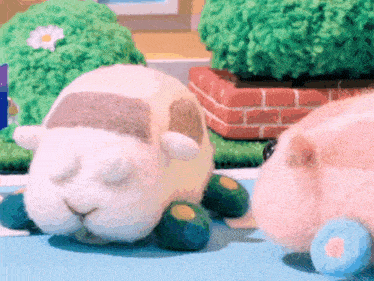 two stuffed animals are laying on a blue surface .