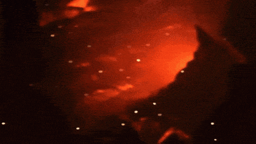 a close up of a soldier 's face with a fire behind him