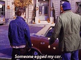 two men standing next to a car with the words someone egged my car