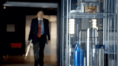 a blurry picture of a man in a suit and tie walking down a hallway