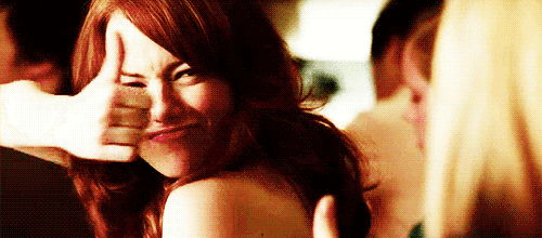 a woman with red hair is making a funny face with her hand .