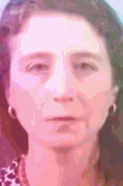 a close up of a woman 's face with a pink and purple background