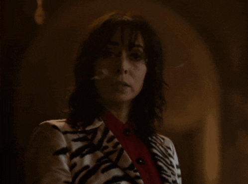 a woman wearing a zebra print jacket and red shirt
