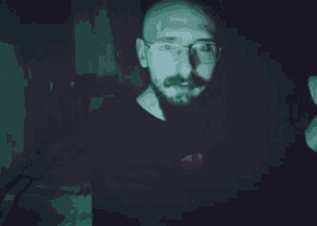 a person in a dark room with a green background