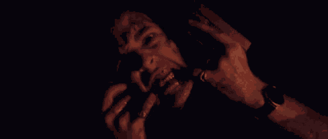 a man with blood on his face is holding a gun .