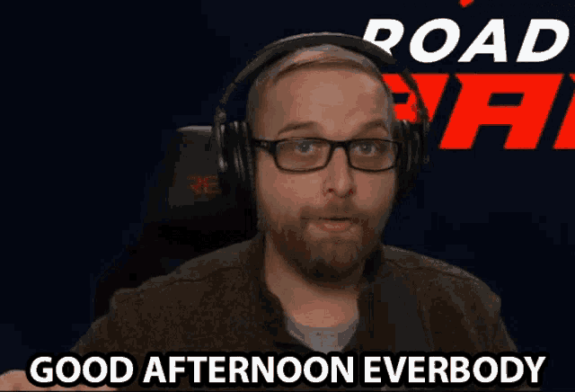 a man wearing headphones and glasses says " good afternoon everbody "