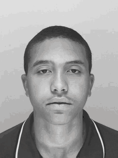 a black and white photo of a young man with a shaved head