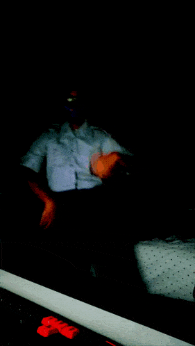a man wearing a blue mask and sunglasses stands in the dark
