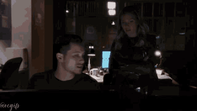 a man and a woman are looking at a computer screen with the hashtag @regifs on the bottom right