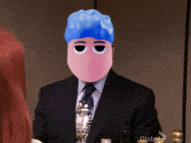 a man in a suit and tie with a blue hat on his head