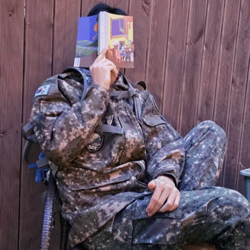 a man in a military uniform has a book on his face