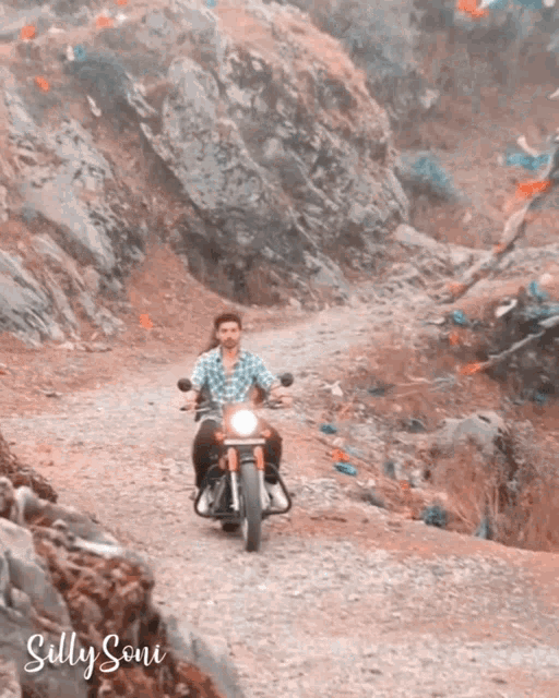 a man riding a motorcycle down a dirt road with silly soni written on the bottom right