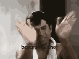 a man with a towel around his neck is making a funny face .