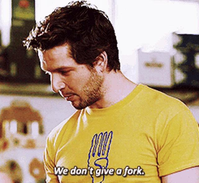 a man wearing a yellow shirt that says we don 't give a fork