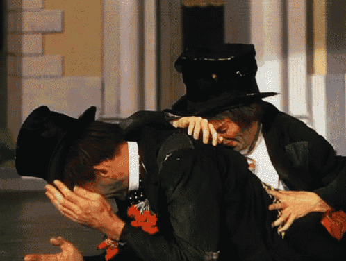 a man in a top hat kisses another man