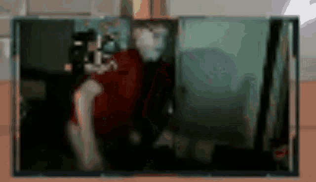 a blurry picture of a man in a red shirt with the letter m on it