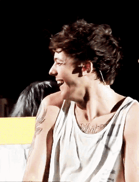 a man wearing a white tank top has a tattoo on his chest that says " what "
