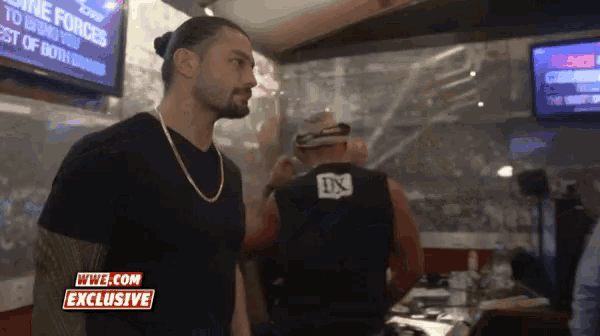 a man standing in front of a sign that says wwe com exclusive