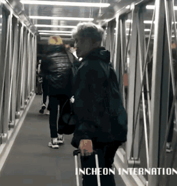 a person walking down a hallway with the words incheon international written on the bottom