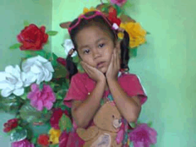 a little girl wearing a pink shirt with a bear on it